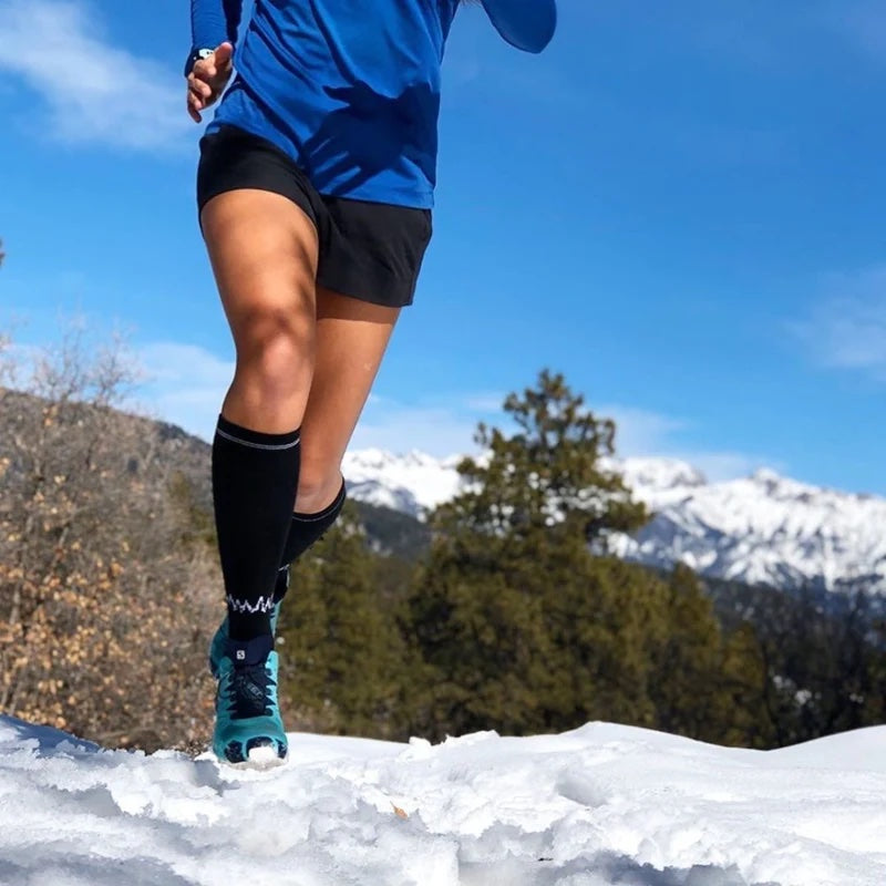 A runner wearing Wul's merino wool socks is running along a path into snow.