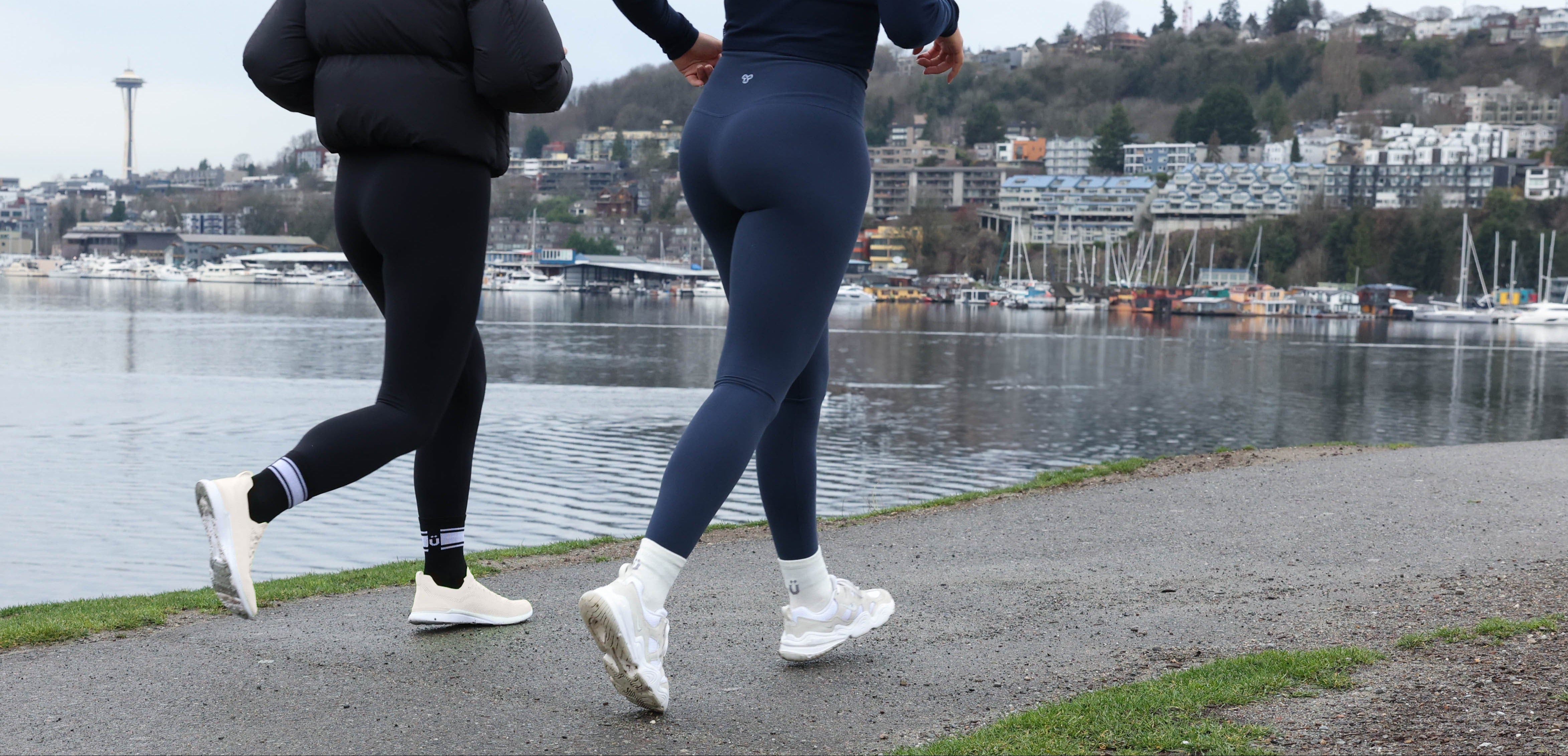 Two people are running on a trail along the Seattle waterfront.