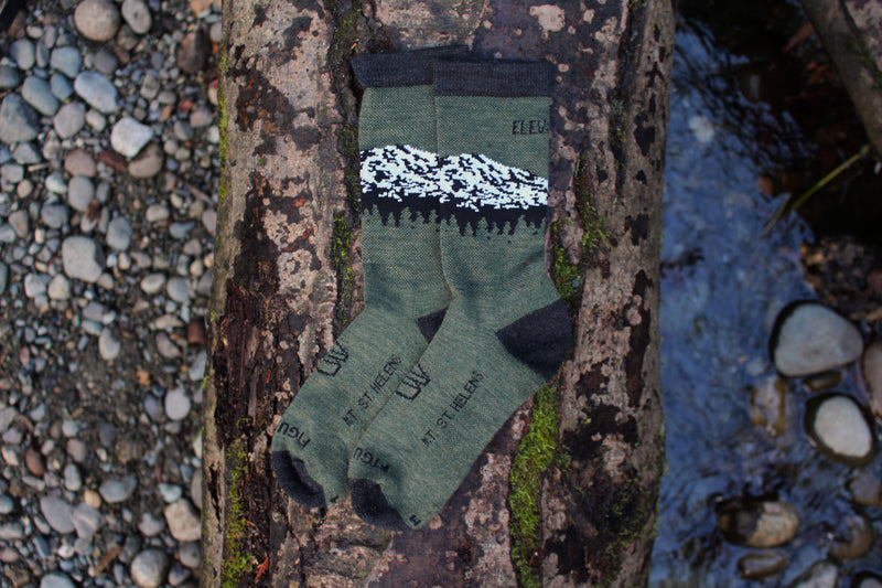 A Picture of Wul's merino wool socks laying on a log. 